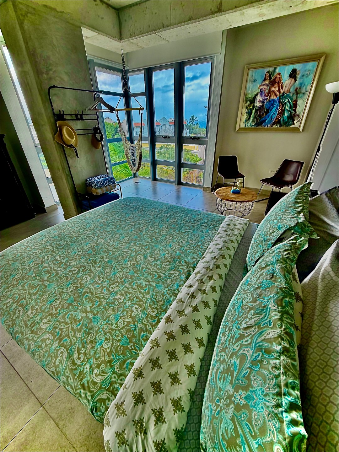 Bedroom with floor-to-ceiling windows and city-and-greenery views at a Stay Here PR rental in Atlantis, Puerta de Tierra