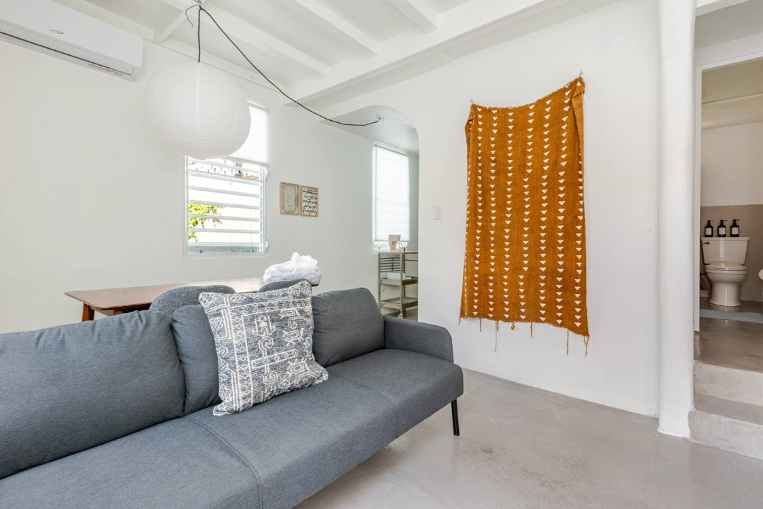 Bright living room with local art at Lealtad Secret Garden Loft near Calle Cerra, Santurce